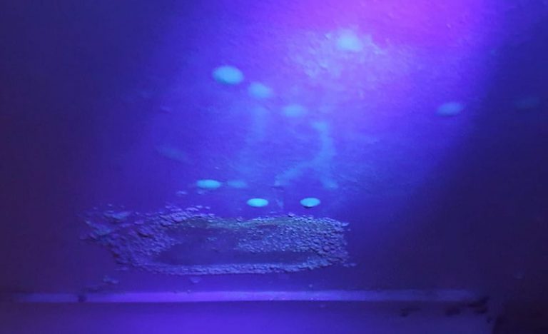 Superfície com marcas visíveis sob iluminação violeta