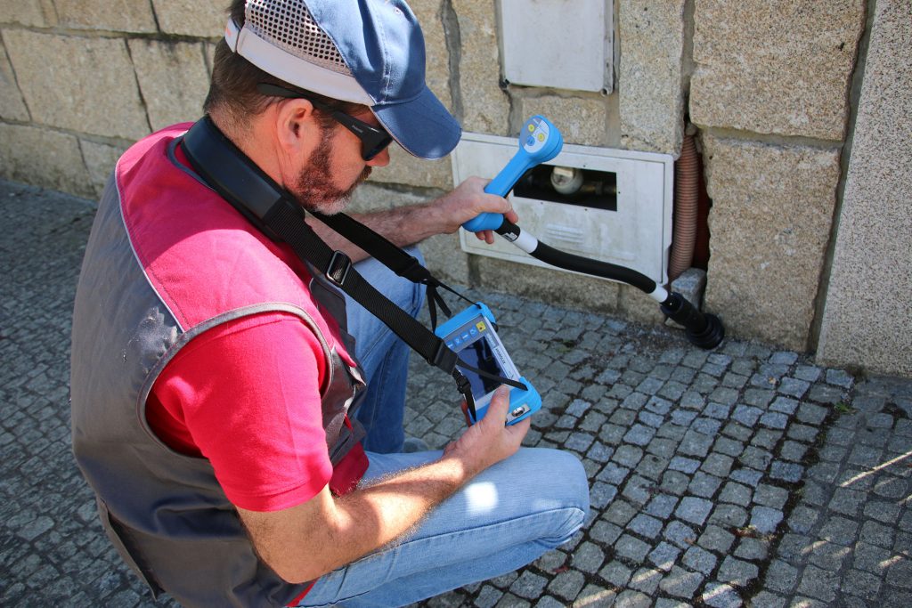 Técnico a utilizar equipamento de pesquisa junto de um contador de água